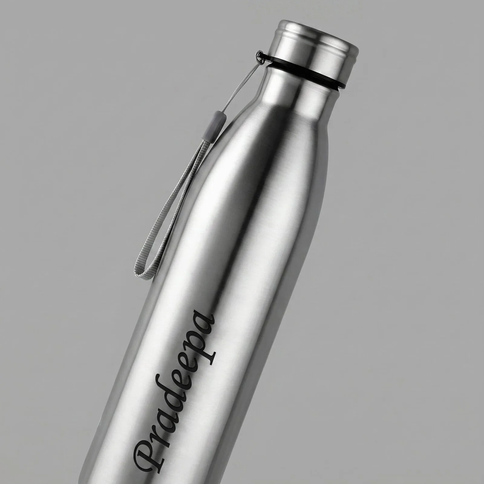 Personalized stainless steel water bottle with custom engraved name, leak-proof cap, and carry strap for office, gym, travel, and daily hydration.