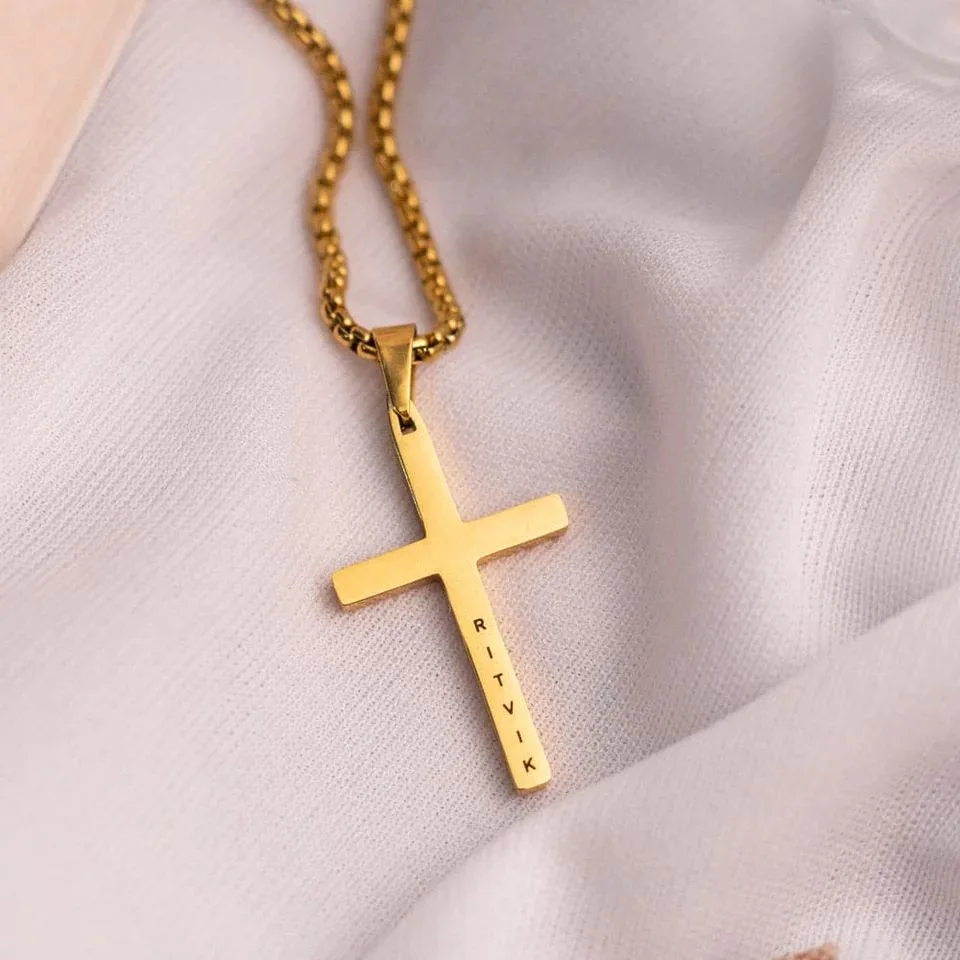 Gold cross pendant on a chain engraved with a personalised name