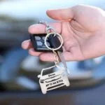 Custom car keychain with name and number plate held with car keys
