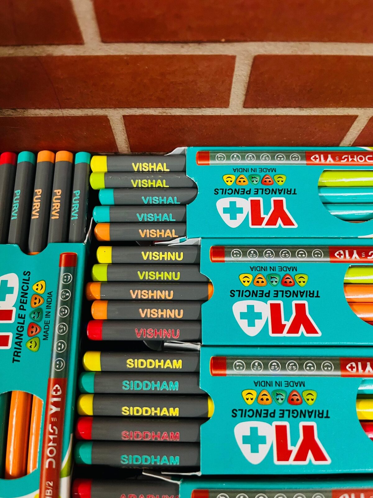 Triangle school pencils printed with childrens names in boxes