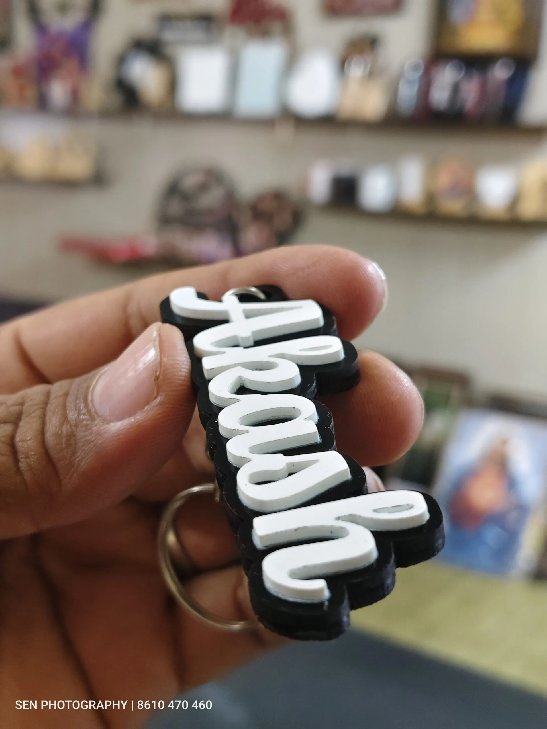 Black and white acrylic cut name keychain held in hand