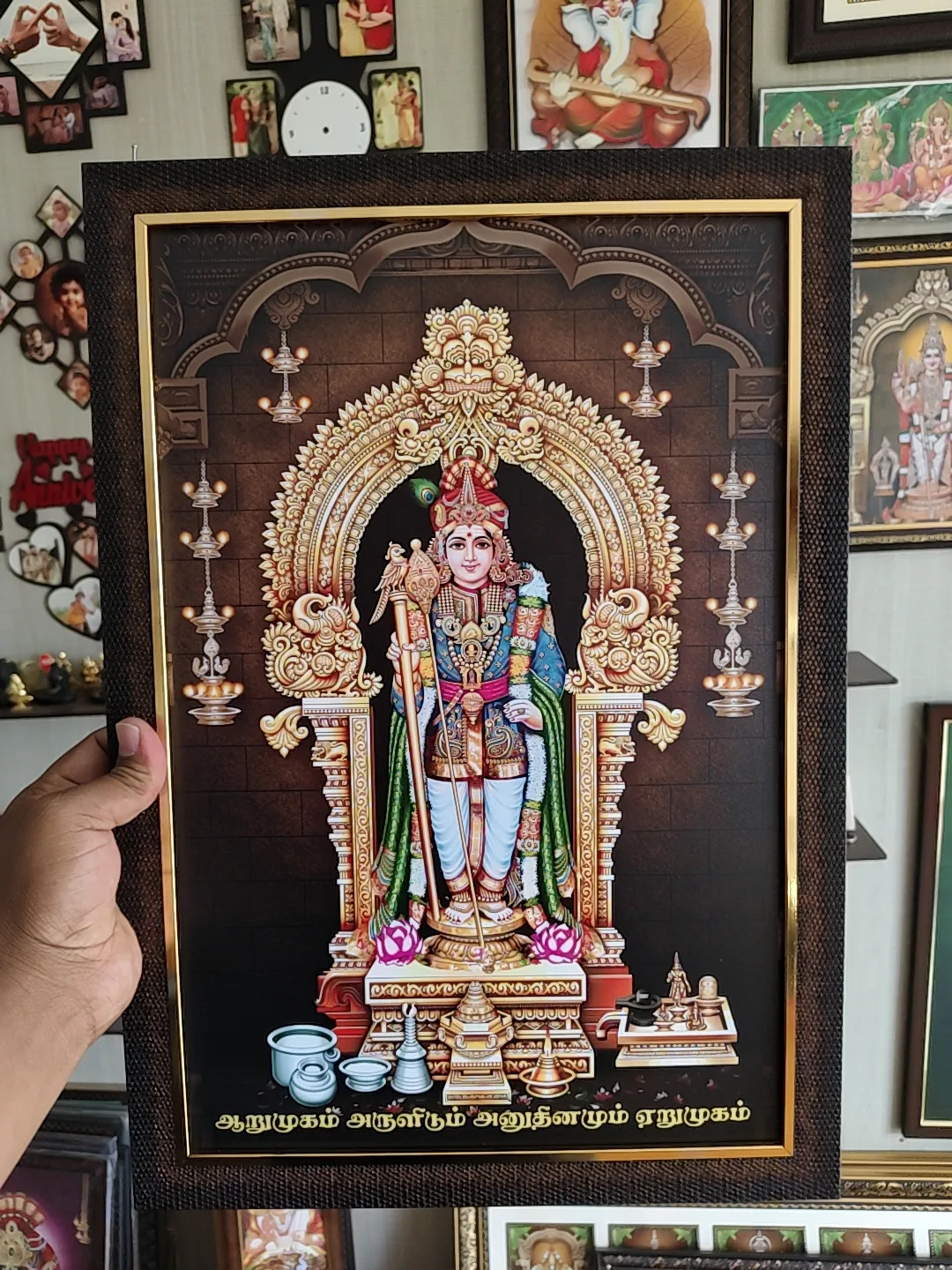 Framed Murugan picture held in hand