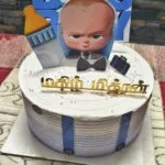 Tamil name cake topper in gold on a white cake