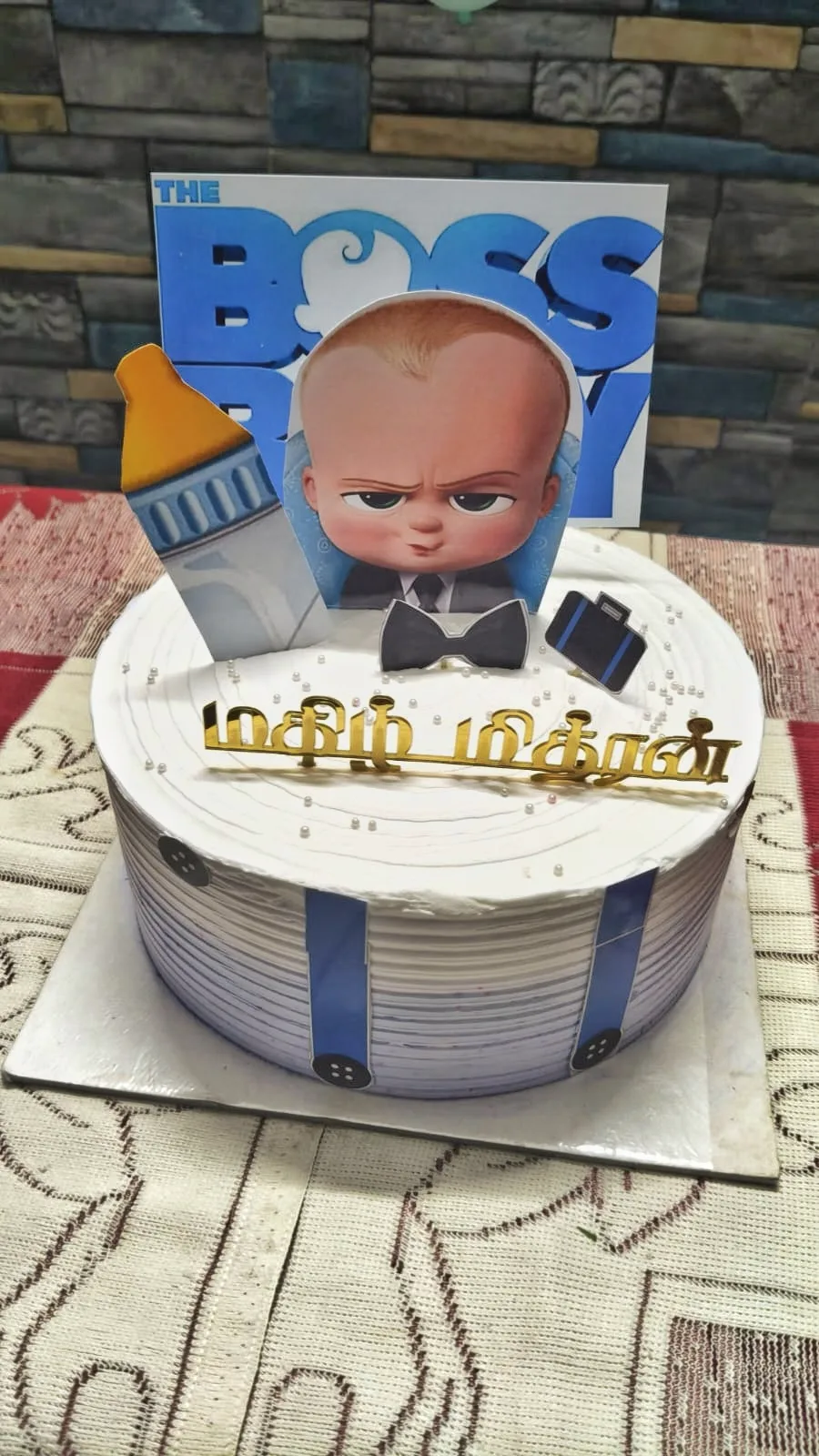 Tamil name cake topper in gold on a white cake