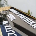 Raised white lettering on a compact acrylic name plate