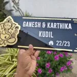 Black acrylic name board with gold Ganesha and Ganesh Karthika Kudil lettering