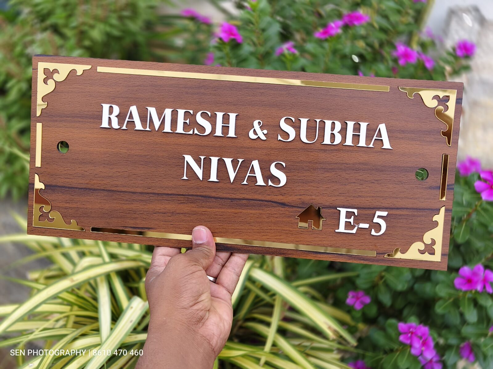 Wooden name plate with gold border reading Ramesh and Subha Nivas E-5