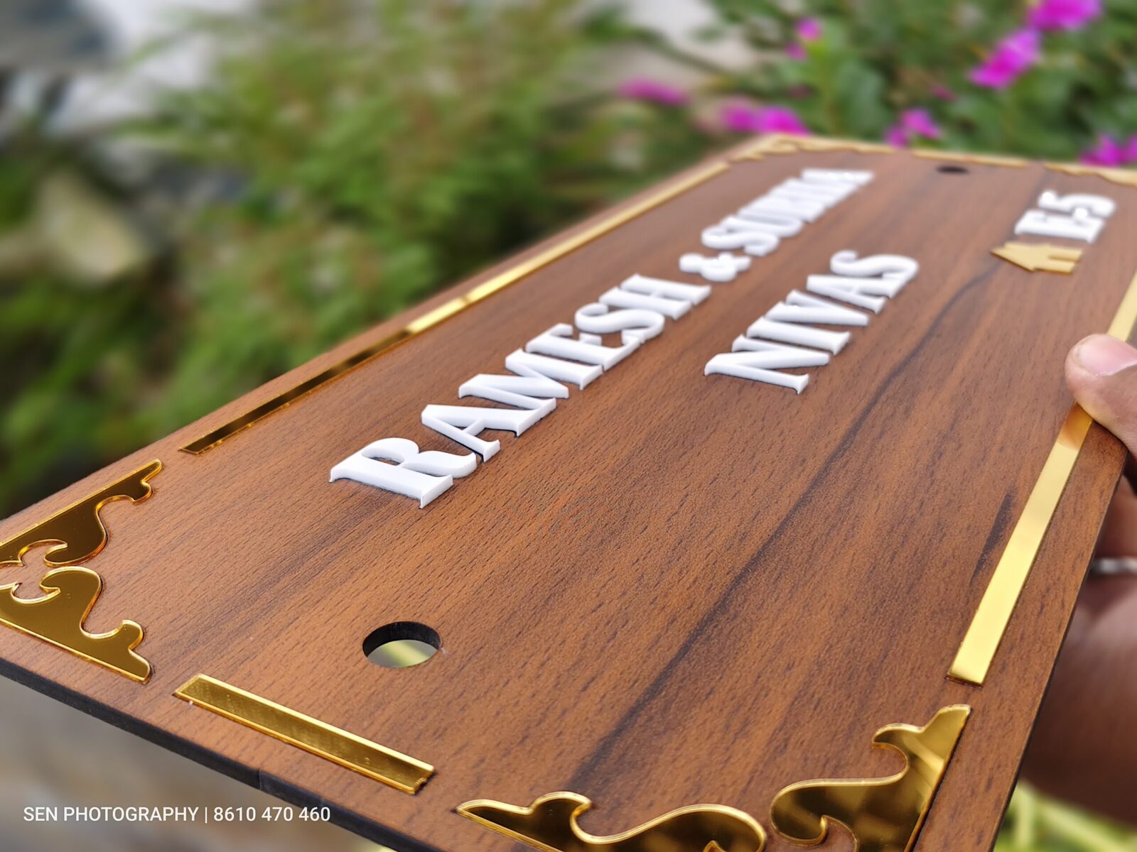 Angled view of a wooden name board with raised white lettering
