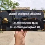 Tamil house name board with names and qualifications in gold lettering