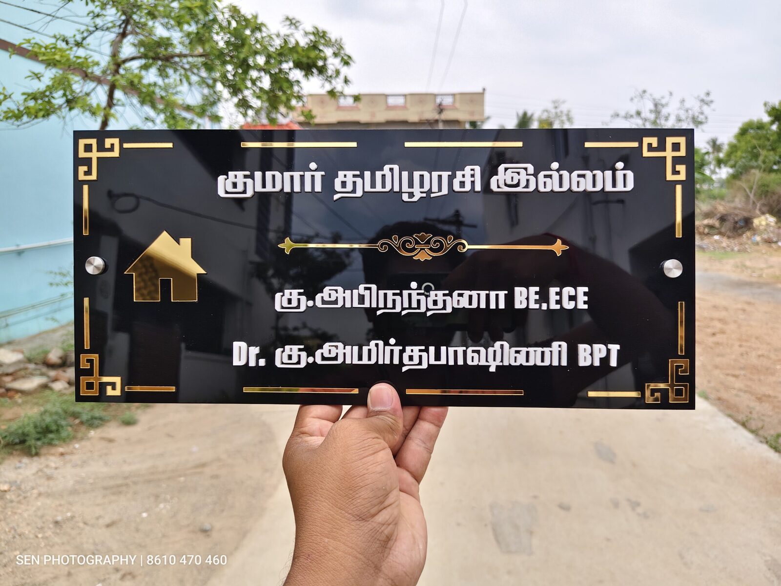 Tamil house name board with names and qualifications in gold lettering