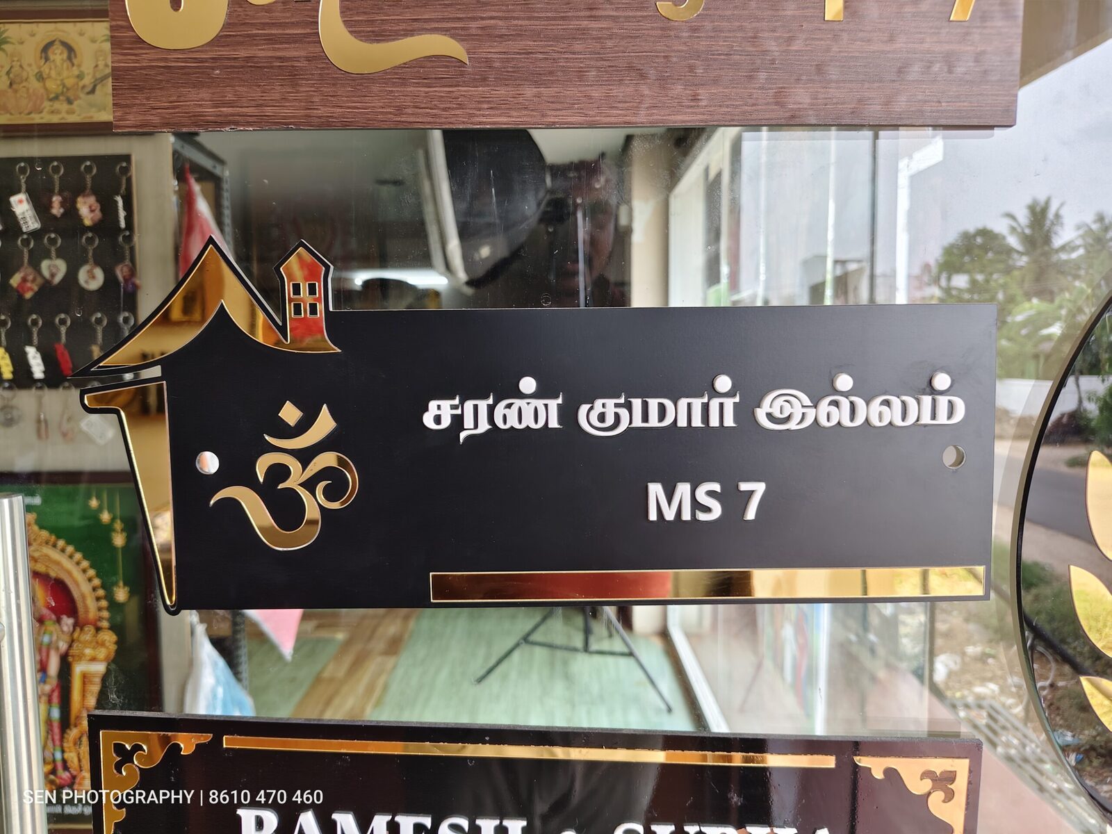 Black acrylic Tamil name board reading Saran Kumar Illam with om symbol