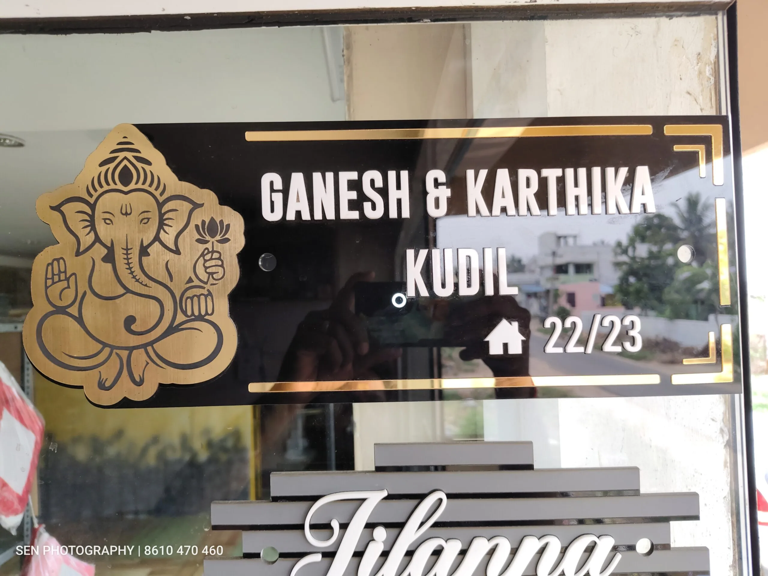 Black and gold acrylic name plate mounted on a gate