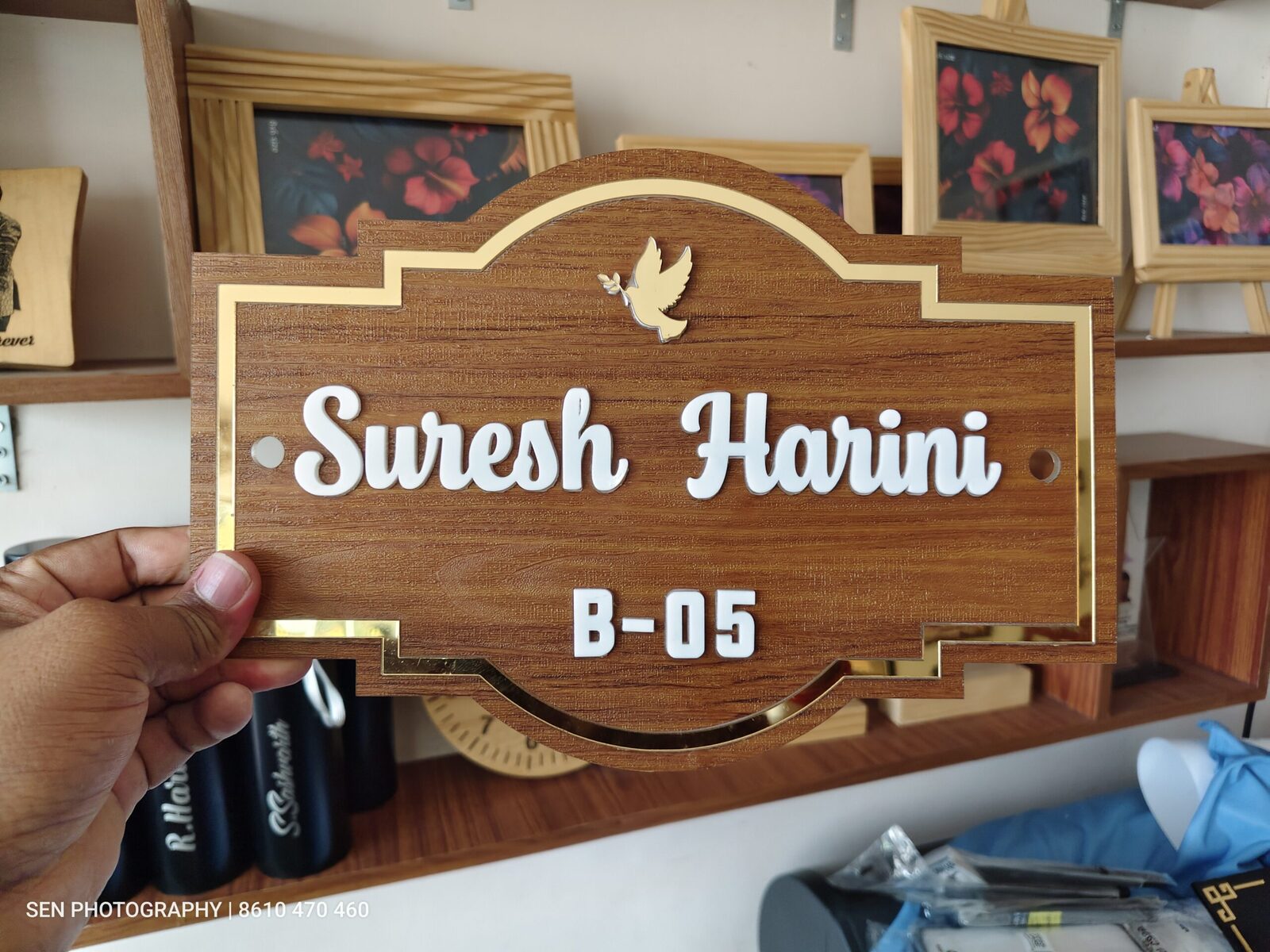 Shaped wooden name board with gold border reading Suresh Harini B-05