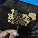 Gold mirror acrylic cake topper reading Happy Birthday with a name