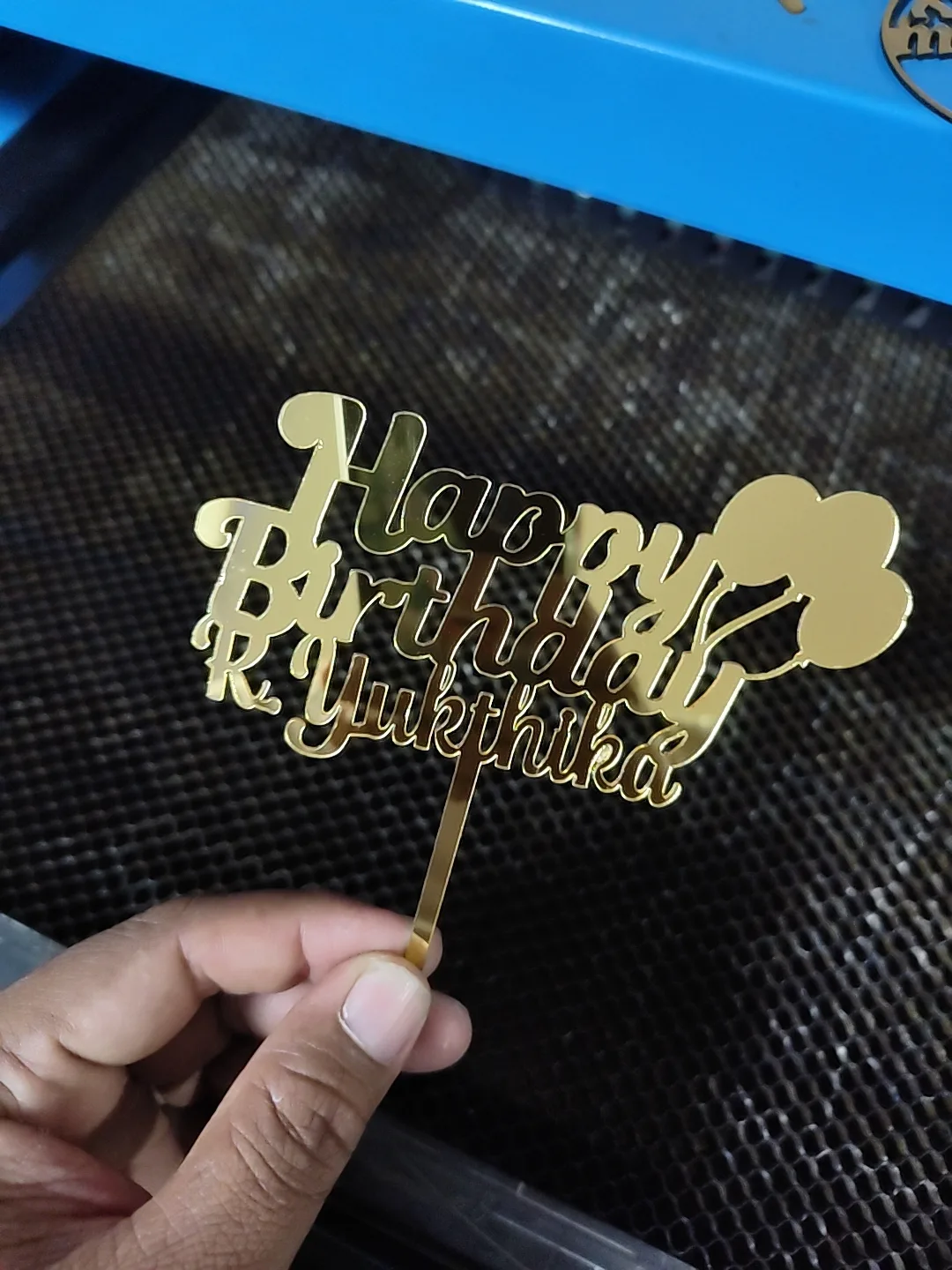 Gold mirror acrylic cake topper reading Happy Birthday with a name