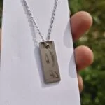 Steel bar pendant engraved with a custom design on a chain