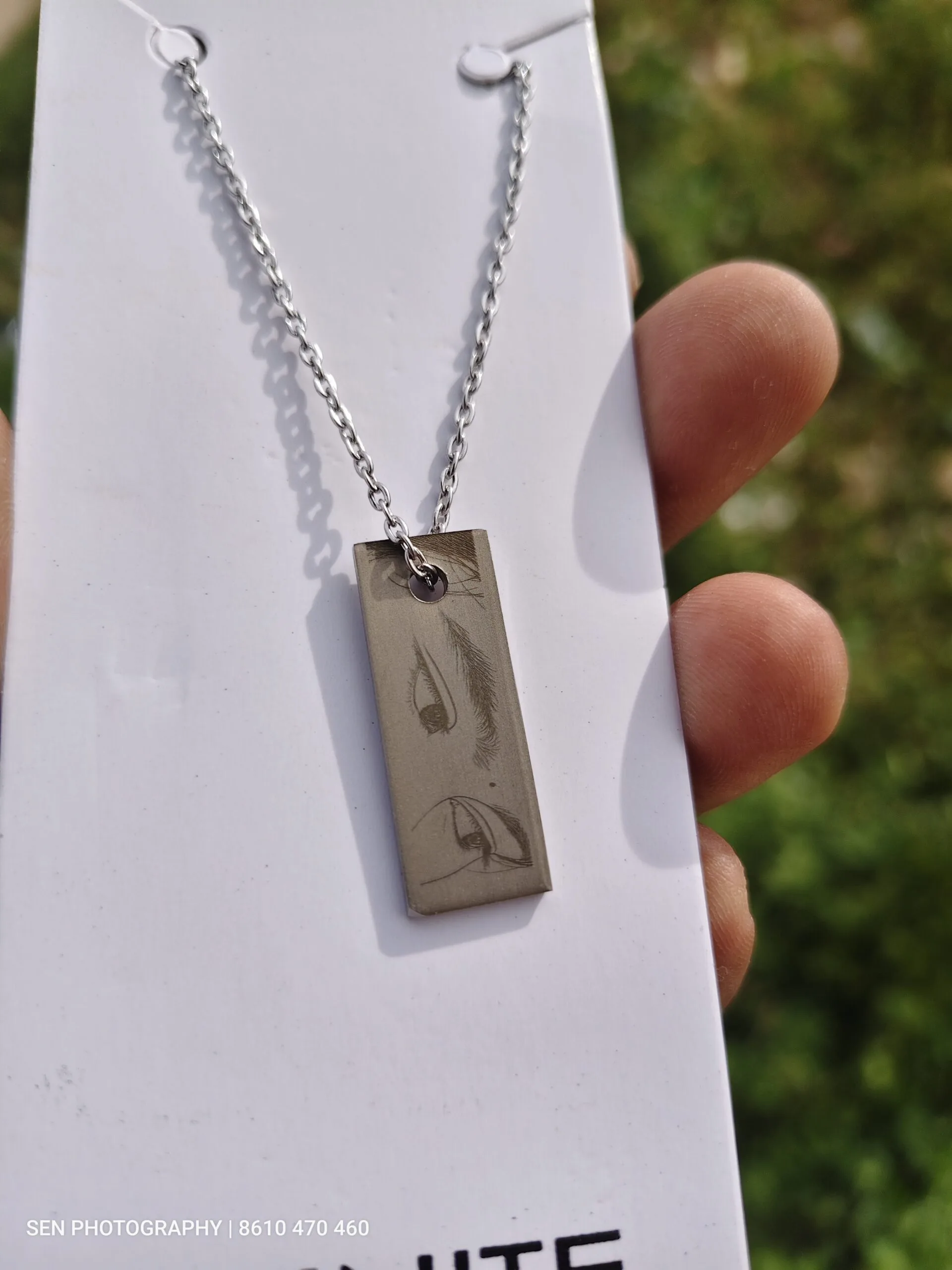 Steel bar pendant engraved with a custom design on a chain