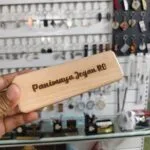 Engraved sliding wooden pen case held in hand