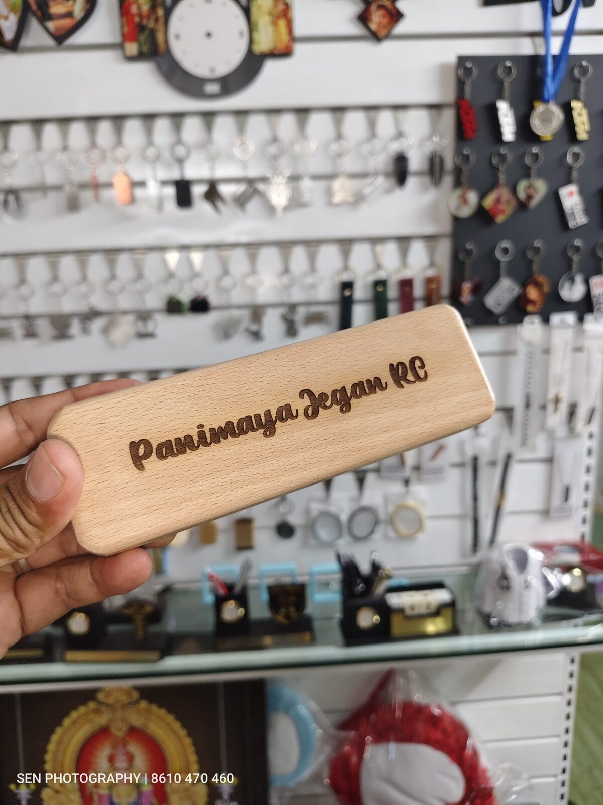 Engraved sliding wooden pen case held in hand