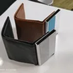 Metal card holder popping out of a slim leather wallet