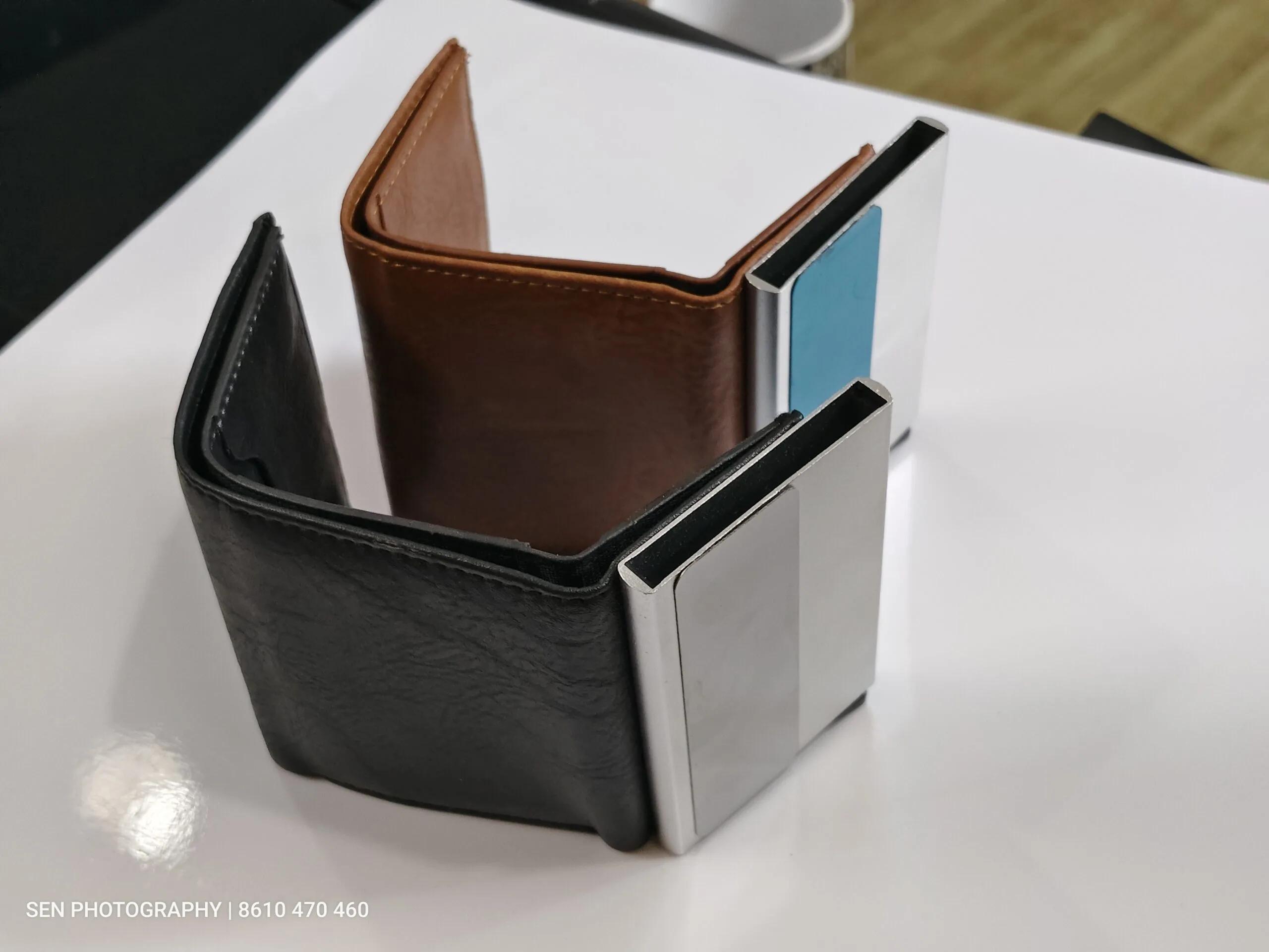 Metal card holder popping out of a slim leather wallet